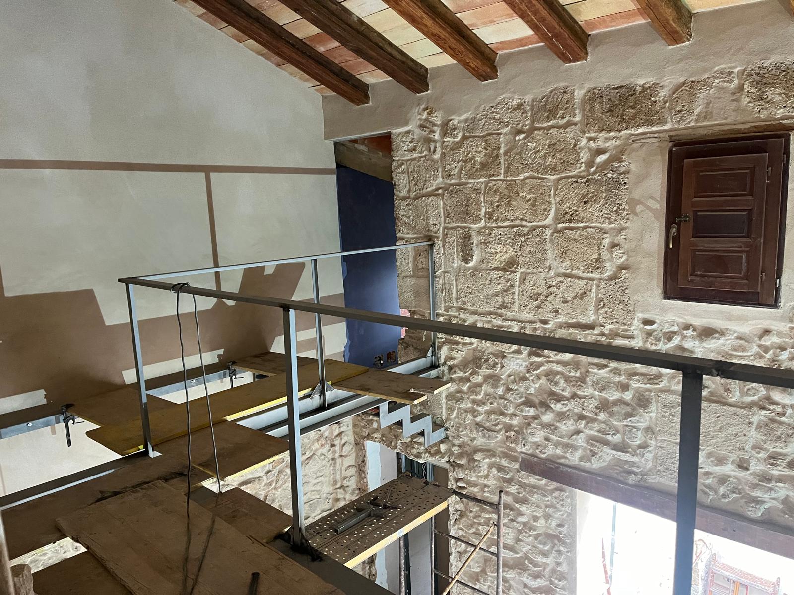 Escalera metálica y pasarela interior en vivienda histórica